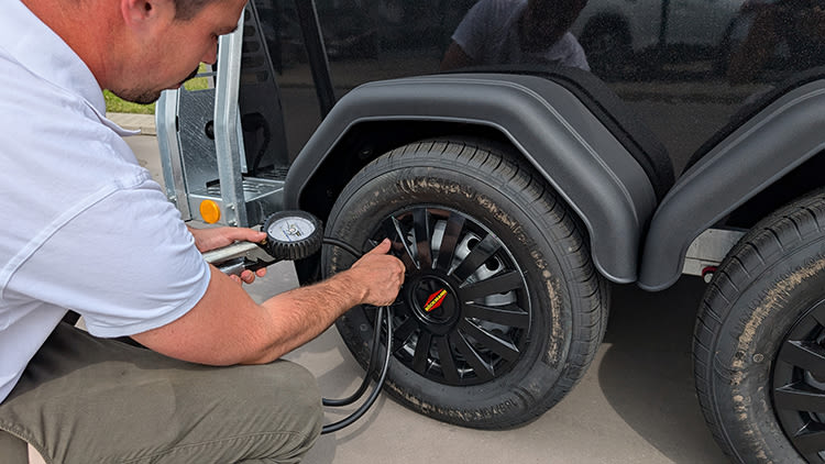 Contrôle de l'usure et de la pression des pneus sur un van à chevaux.